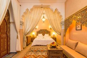 a bedroom with a bed and a table with a bowl of fruit at Riad Tahyra in Marrakesh