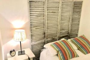 een slaapkamer met een bed met een lamp en een raam bij Flat in historic neighbourhood in Lissabon