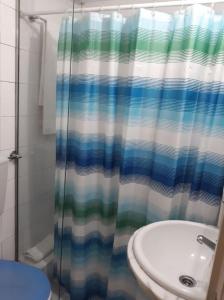 a bathroom with a shower curtain and a toilet at Flat in historic neighbourhood in Lisbon