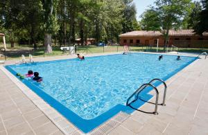 a group of people in a large swimming pool at Camping Fuentes Blancas in Burgos