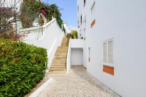 Casas Barulho Apartments Old Town في ألبوفيرا: درج في مبنى أبيض بجدران بيضاء
