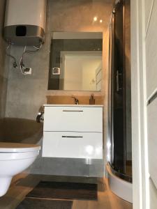 a bathroom with a white sink and a toilet at Apartament koloru morza - Turkus in Łeba