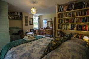 a bedroom with a bed and bookshelves filled with books at Penybanc Farm in Llandysul