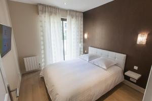 a bedroom with a white bed and a window at Appartement Gerland - Centre historique - in Dijon