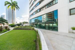 un edificio de oficinas con césped delante en Excelente 2 Quartos em Setúbal Boa Viagem eal para famílias e executivos PM306, en Recife