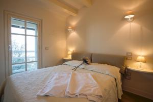 Un dormitorio con una cama con sábanas blancas y una ventana. en Bianca la Luna amazing villa lakeside view, en Magione 46 fotos más