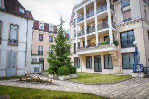 un edificio de apartamentos con un árbol en el patio en Appartement Gerland - Centre historique -, en Dijon