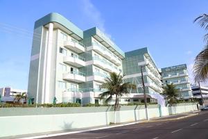 un grand bâtiment avec des palmiers en face d'une rue dans l'établissement Real Classic Hotel, à Aracaju