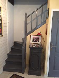 a staircase with a black stair case and a blue door at Maison de pêcheur 30m de la plage in Luc-sur-Mer