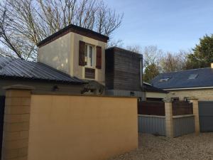 una casa con recinzione e una casa con tetto di Maison de pêcheur 30m de la plage a Luc-sur-Mer