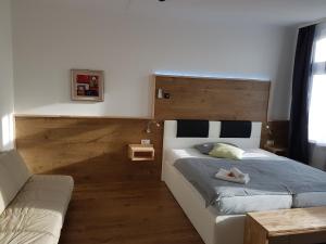 a bedroom with a bed and a couch at Bennetts Restaurant und Hotel in Wittingen