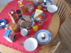 a table with breakfast food on a red table cloth at Lillåns B&B in Örebro