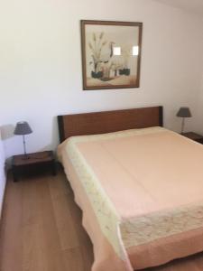 1 dormitorio con cama y espejo en la pared en Maison L'Oranger avec piscine - Domaine E Case di Cuttoli, en Cuttoli-Corticchiato