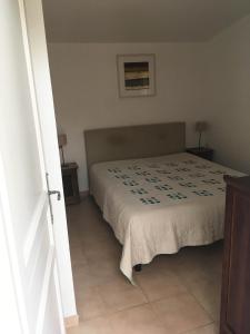 1 dormitorio con cama con colcha en Maison L'Oranger avec piscine - Domaine E Case di Cuttoli, en Cuttoli-Corticchiato