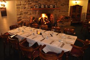 a dining room with a table and a fireplace at Marritz Hotel in Perisher Valley