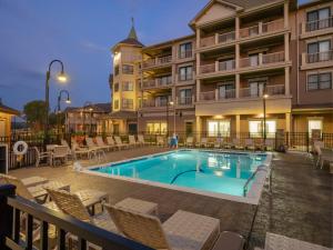 une piscine dans un hôtel avec des chaises et un bâtiment dans l'établissement Chautauqua Harbor Hotel - Jamestown, à Celoron