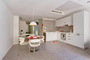 a kitchen with white cabinets and a table and chairs at Valletta Studio Apartment in Valletta