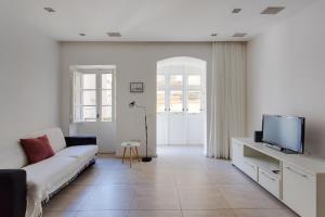 a living room with a couch and a tv at Valletta Studio Apartment in Valletta