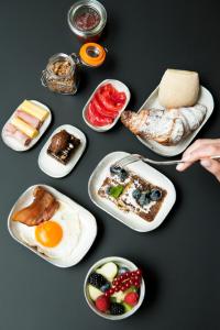 a table topped with plates of breakfast foods at Hotel Riga in Antwerp