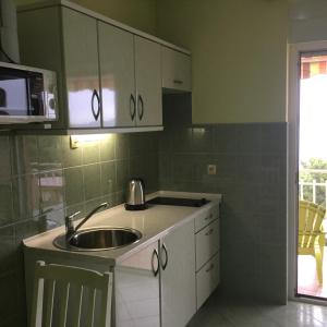 cocina con fregadero y microondas en Apartments Žgogo, en Trogir