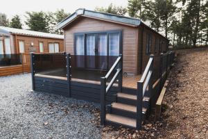 a tiny house with a staircase leading to a cabin at Atlas Ovation Lodge in Auchterarder