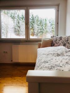ein Schlafzimmer mit einem Bett und zwei Fenster mit Schnee in der Unterkunft Family Apartment Alpine Living 2-4 Persons in Radstadt