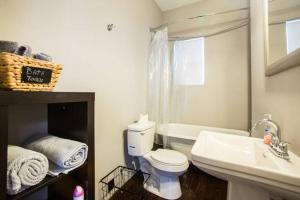 a bathroom with a white toilet and a sink at Modern Condo Blocks from Quarters in New Orleans