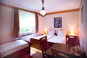 a room with two beds and a table and a dining room at Villa Ambra in Osowa