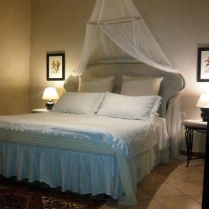 - une chambre avec un lit blanc à baldaquin dans l'établissement Agriturismo Debbione Marconi, à Suvereto