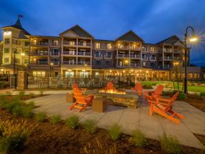 un hôtel avec des chaises oranges et un foyer extérieur dans l'établissement Chautauqua Harbor Hotel - Jamestown, à Celoron