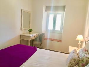 a bedroom with a bed and a desk and a window at Casa do Chaparral campo e praia in Cercal