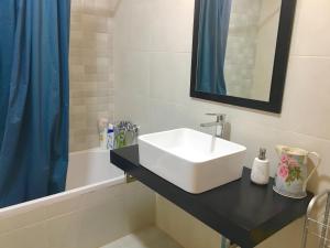 a bathroom with a white sink and a bath tub at Casa do Chaparral campo e praia in Cercal +42 photos