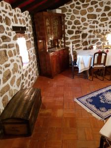 a dining room with a table and a stone wall at Dona Gracia Belmonte in Belmonte