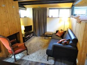 a living room with a couch and a chair at De Oude Stoffeerderij in Dussen