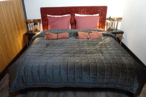 a large bed with a blue comforter and pillows at De Oude Stoffeerderij in Dussen