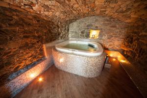 a bathroom with a tub in a stone wall at Souvenir De Tsaneli in Roisan