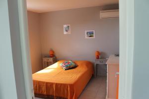 - une petite chambre avec un lit et un oreiller dans l'établissement La villa larimar, à Saint-François