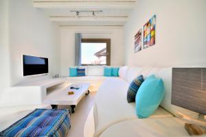 a living room with a white couch and a tv at Villa Kimothoe by Thalassa Residence Mykonos in Elia Beach