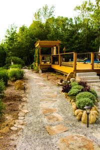 einen Garten mit einem gelben Haus und einigen Büschen in der Unterkunft The Nutmeg Inn in Meredith