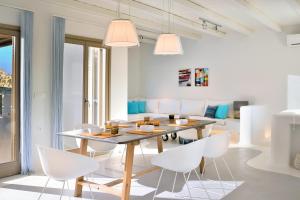 jadalnia ze stołem i białymi krzesłami w obiekcie Villa Kimothoe by Thalassa Residence Mykonos w mieście Elia