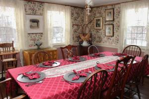 ein Esszimmer mit einem Tisch und einem roten Tischtuch in der Unterkunft The Nutmeg Inn in Meredith