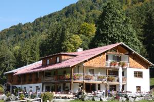 a large building with a mountain in the background at Berggasthof Riefenkopf in Oberstdorf