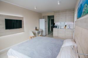 1 Schlafzimmer mit einem großen Bett und einer Küche in der Unterkunft Swiss Quality Apartments (Beach Tower) in Batumi