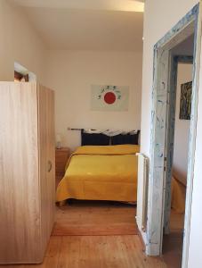 a bedroom with a bed with a yellow bedspread at ArtediMarco in Terlago