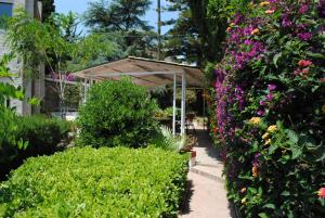 a garden with a pavilion and colorful flowers at Summer Beach Rooms in Fontane Bianche