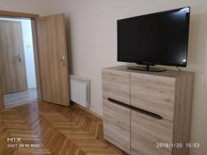 a flat screen tv on a wooden dresser in a room at Apartament Sofia Agroturystyka in Ryczów