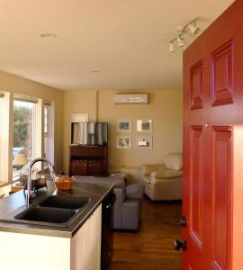 a kitchen with a sink and a living room at AnnArthur Guest House in Nanaimo