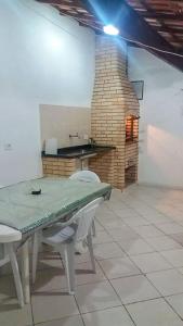 een tafel en 2 stoelen in een kamer met een open haard bij Casa Praia Arpoador in Peruíbe