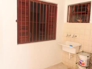 a bathroom with a toilet and a sink and a window at Casa Praia Arpoador in Peruíbe +16 photos