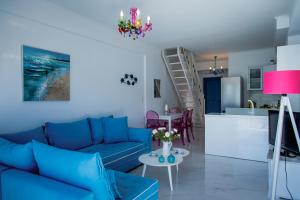 a living room with a blue couch and a kitchen at Seafront Luxury residence with amazing view in Vasiliki